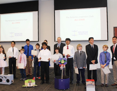 ENSCO President Boris Nejikovsky, back center, with members of the Robotics Inventors Club All Stars and their robots.